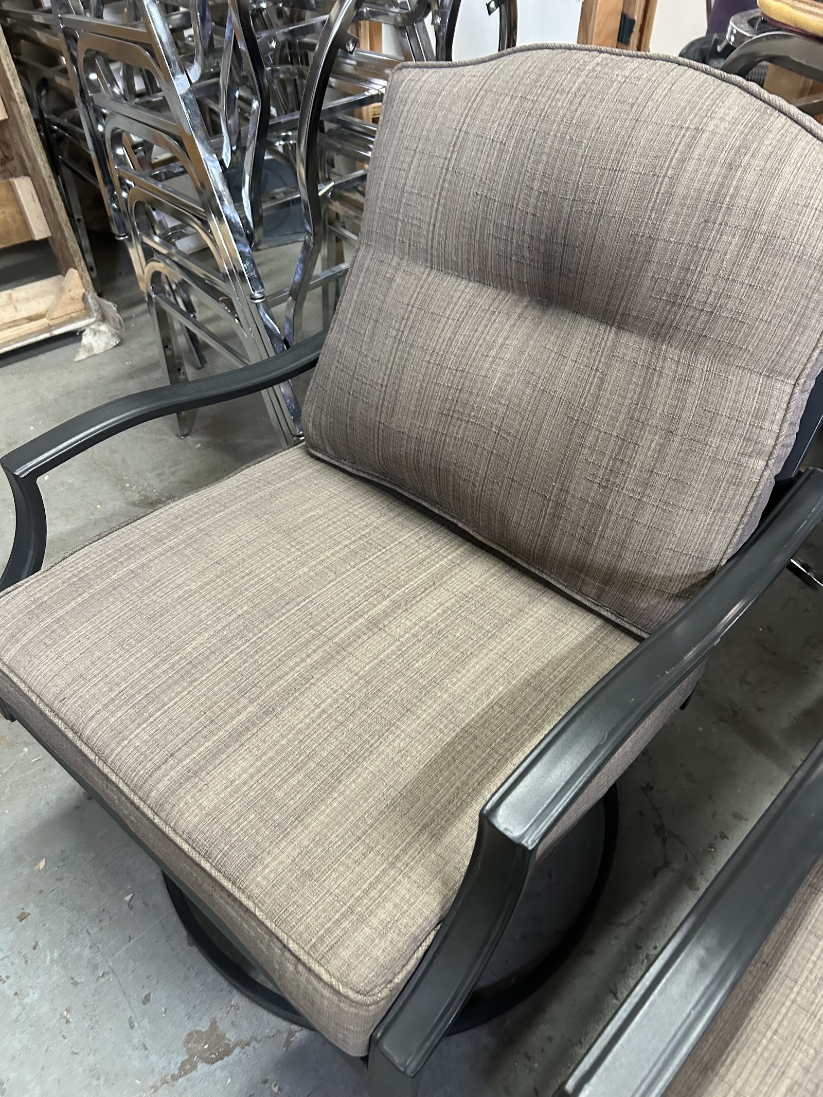 Neutral upholstered seat and back cushions on a dark chair frame