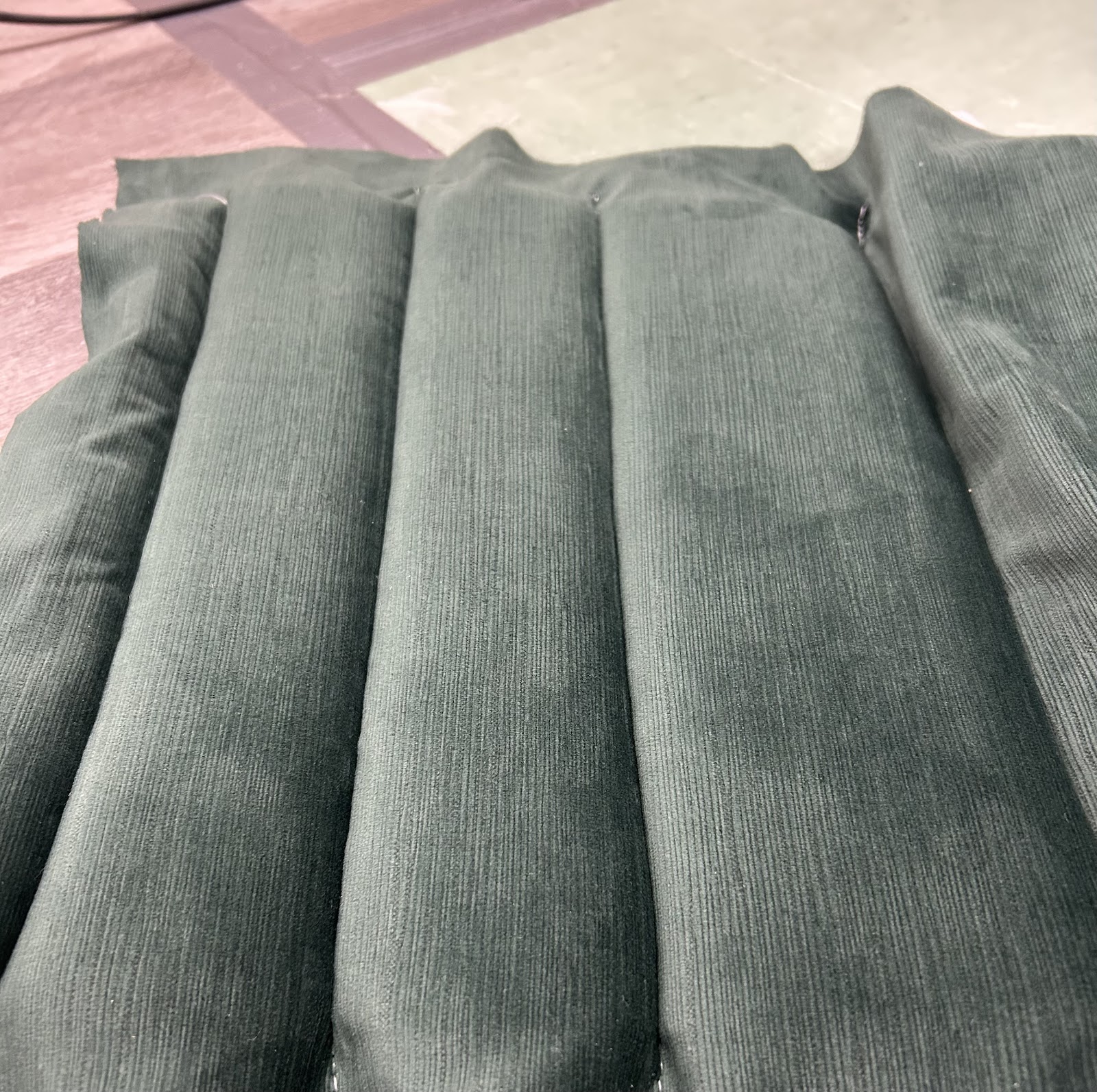 Close-up of green channel-stitched upholstery in the workshop