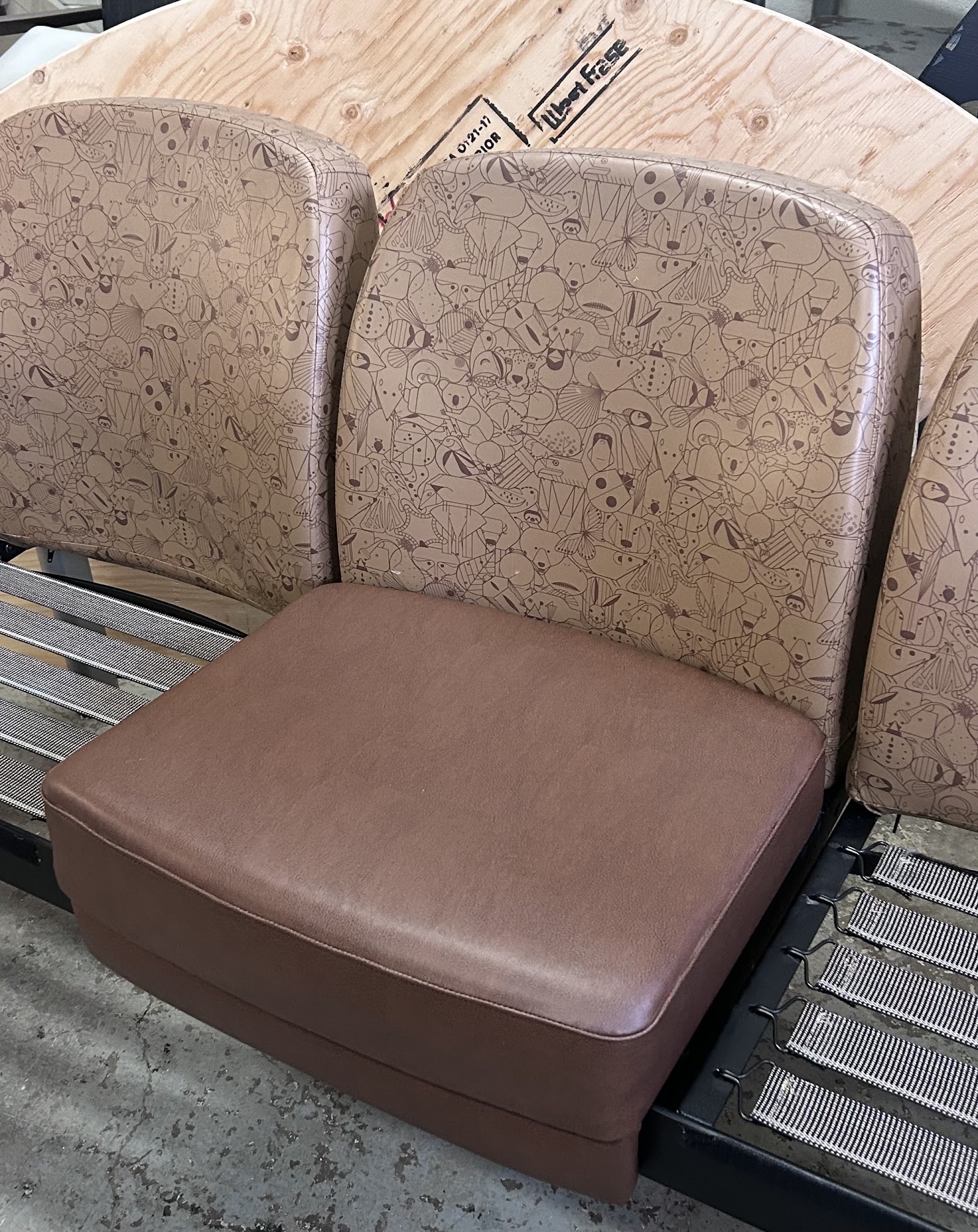 Animal-patterned seat backs and a brown cushion during upholstery work