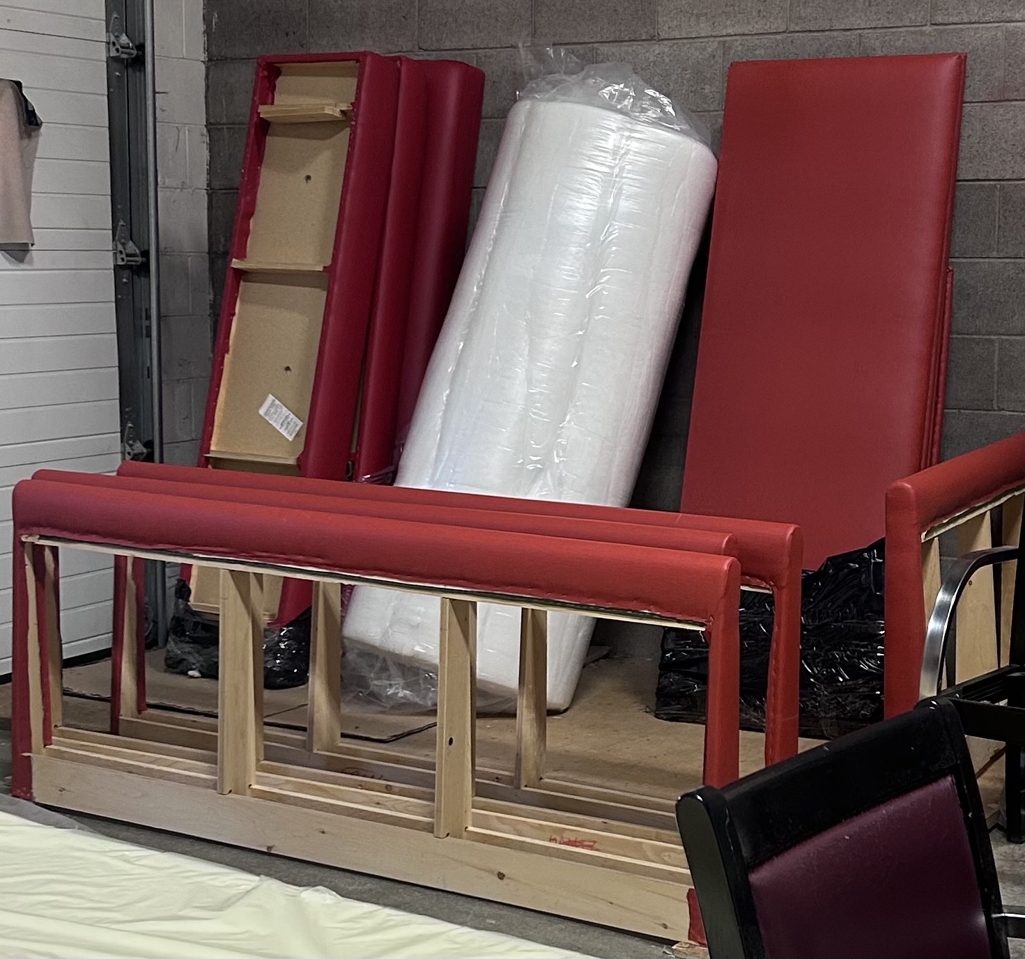 Red upholstered bench components and wooden frames in progress